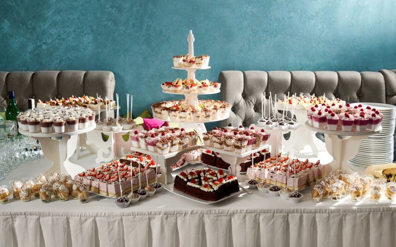 Delicious food on the wooden table Horizontal shot of a candy buffet at the restaurant table full of delicious desserts cakes cheesecakes creamy sweets party festive gathering cafe confectionery celebration.